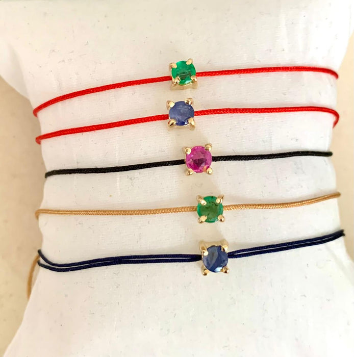 Pulcera de hilo con rubí, zafiro y esmeralda 14k